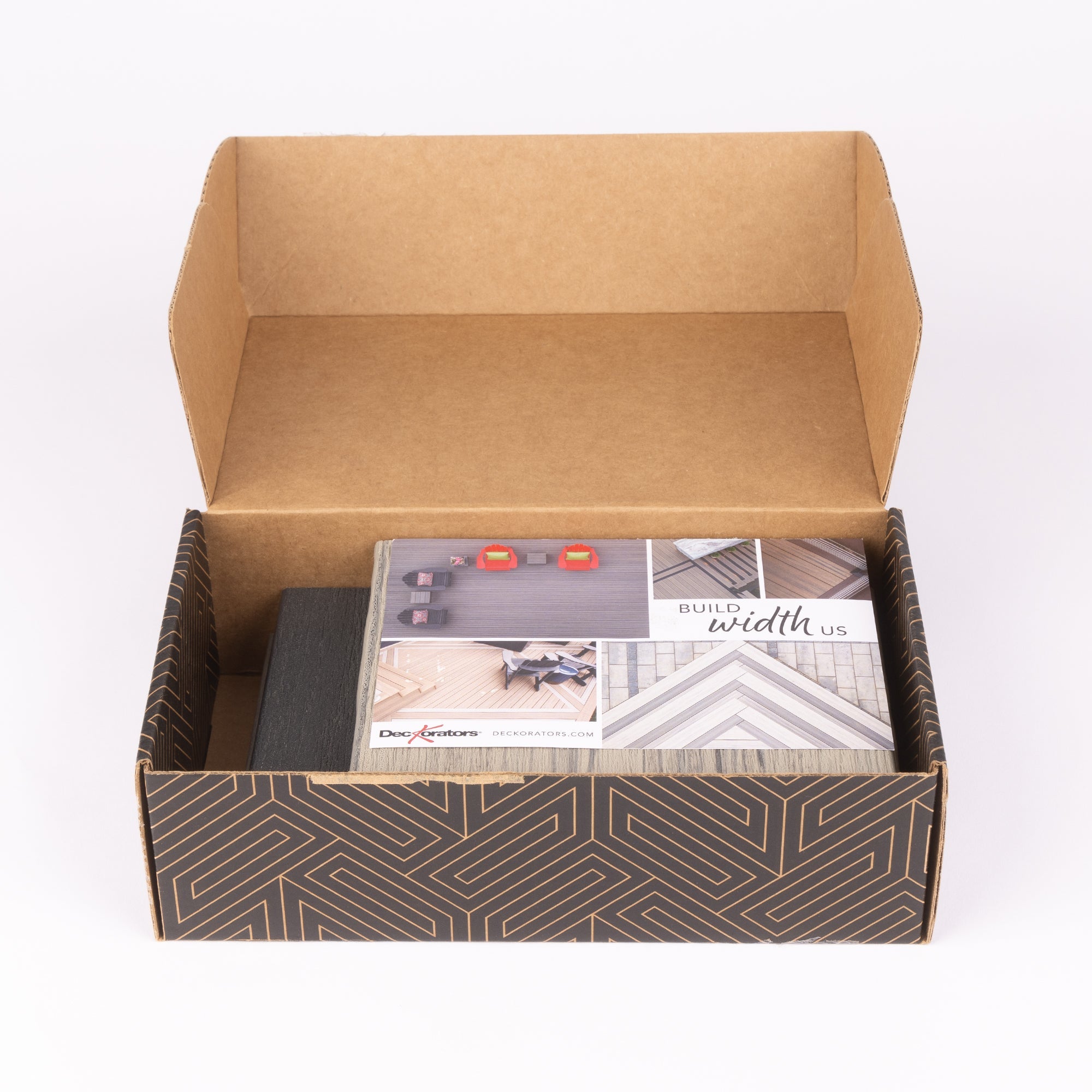 Open cardboard box with a patterned interior, containing a book or manual titled 'Build width Us'.