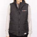 Person wearing a Women's The North Face black puffer vest with Deckorators logo on front left 